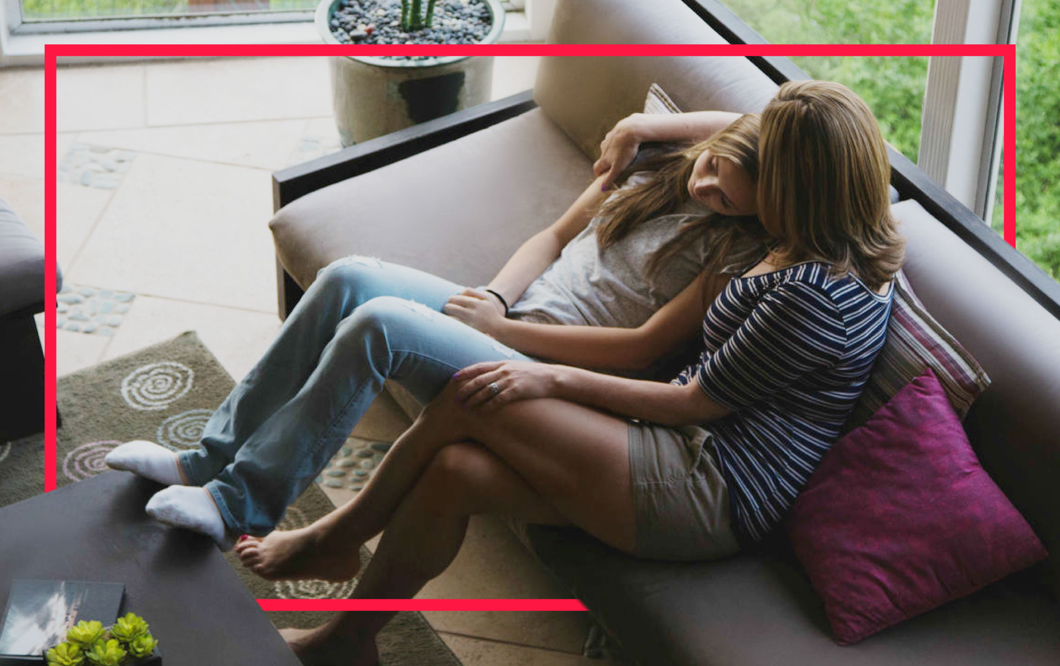 mother-comforting-daughter-on-sofa