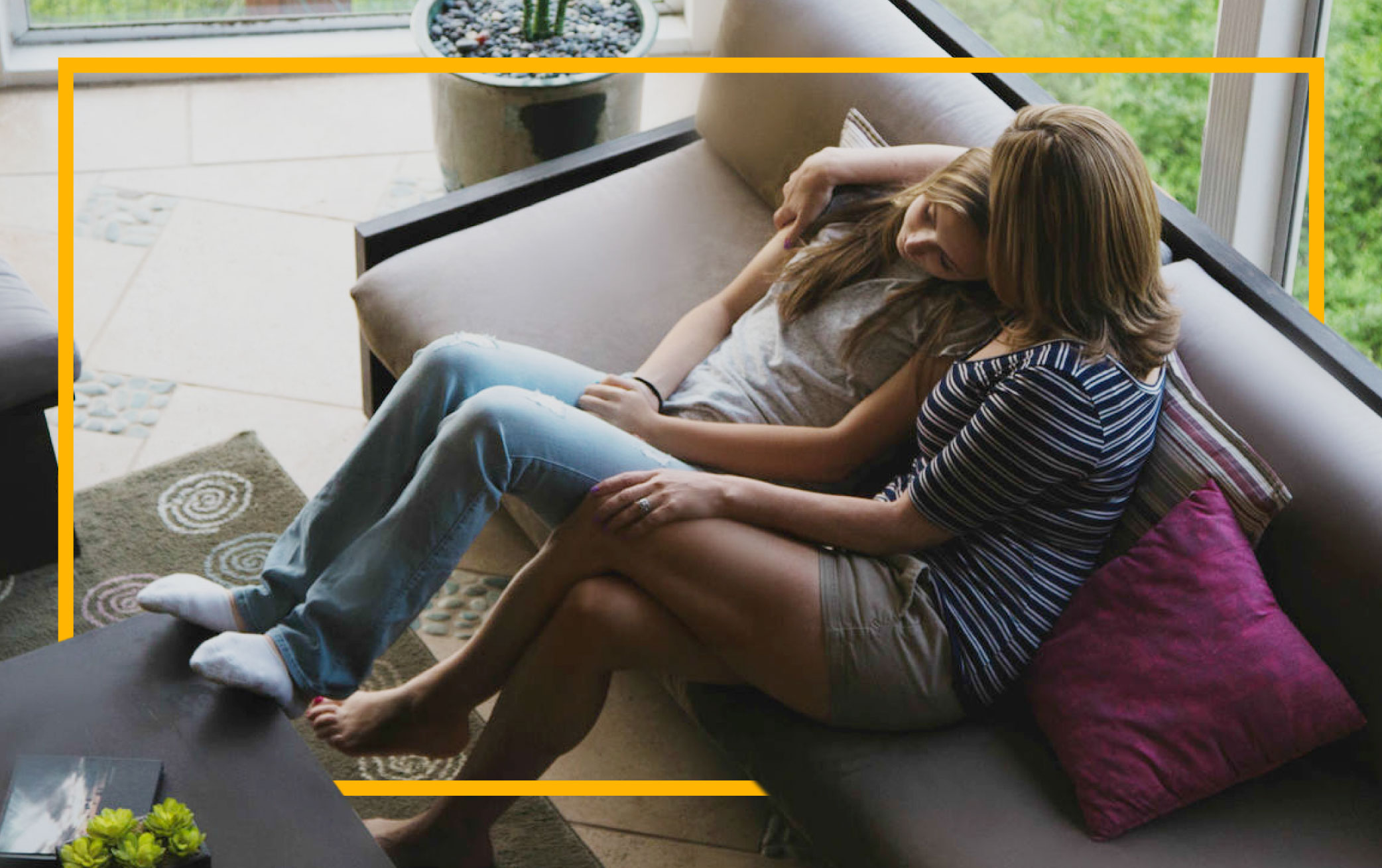 mother-comforting-teenage-daughter-on-sofa